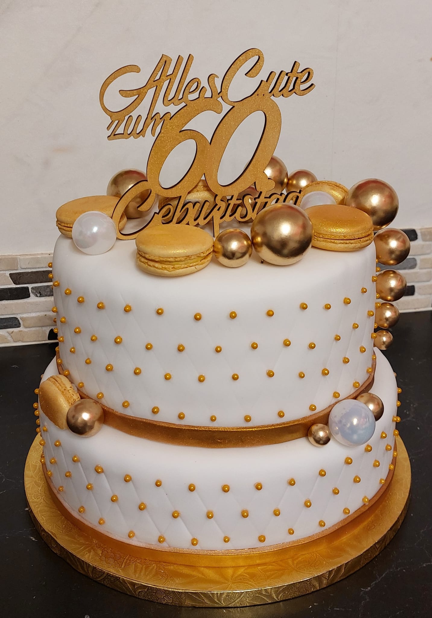 Zweistöckige Geburtstagstorte in Weiß und Gold zum 60. Geburtstag